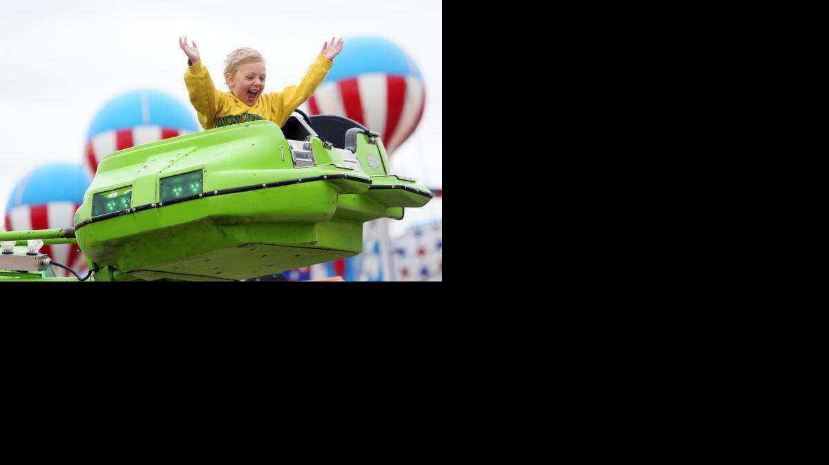 
Airiana Jaworski, 4, waves to her family as she rides the Mini Jets at the Kansas State Fair in Hutchinson on Friday (Sept. 12, 2014)
