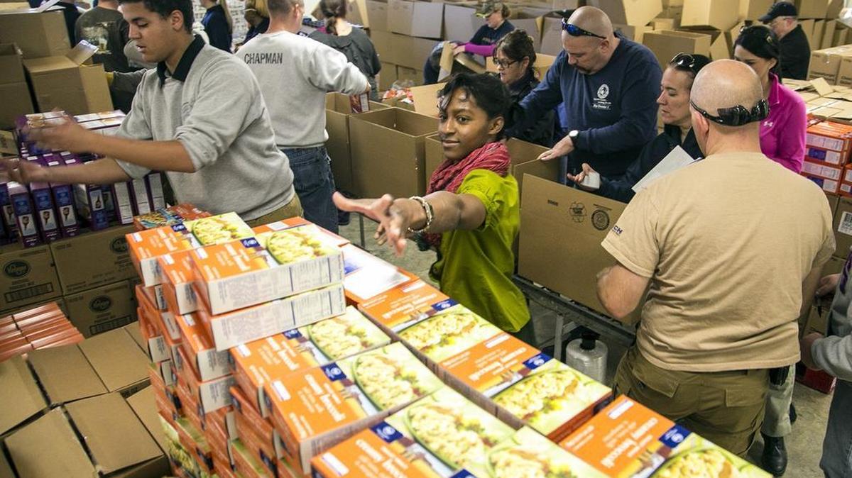 Tabitha Ferguson of the Sedgwick County Sheriff’s Office reaches for a box of stuffing Wednesday during the department’s annual holiday food drive for Sedgwick County residents who need assistance.