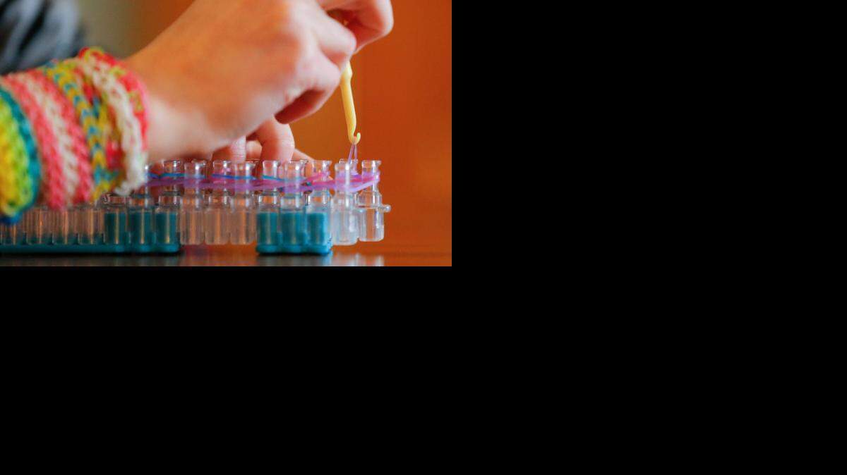 
A girl works on a Rainbow Loom at her home in Wichita. The toy, engineered by two former Wichita State students, has become wildly popular and inspired several copycat versions.
