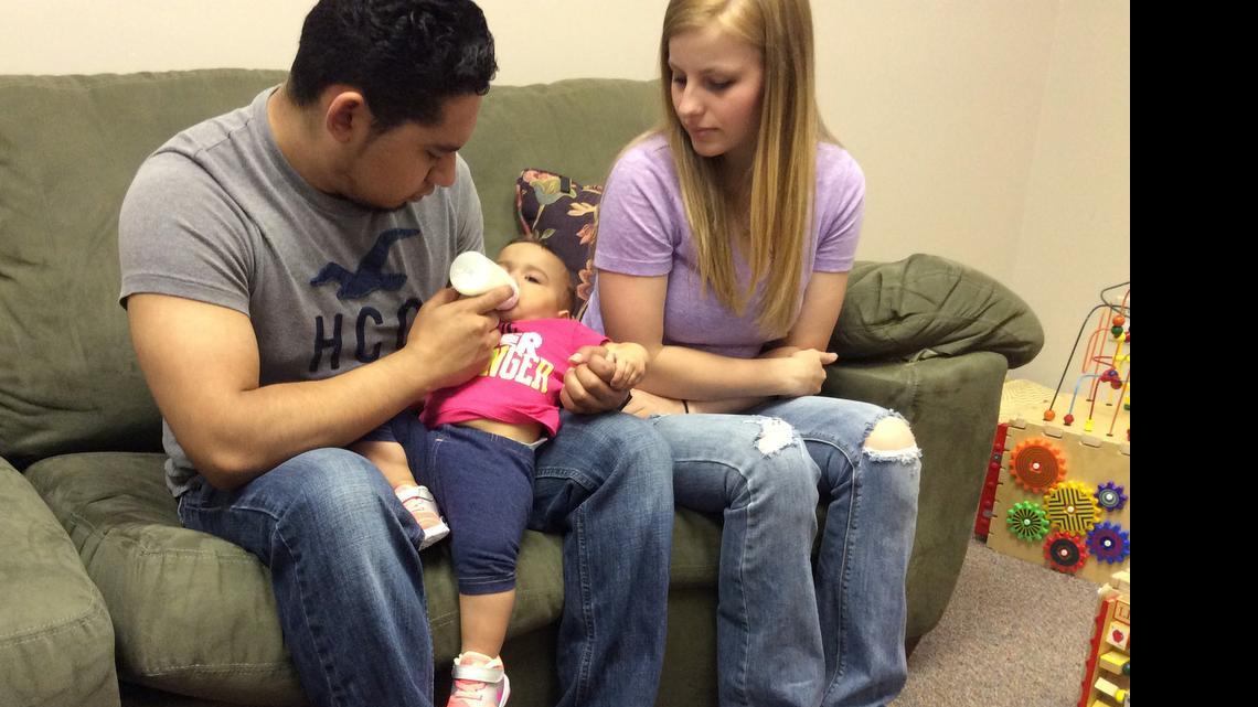 
Juan Ruiz, 19, feeds his 9-month-old daughter, Rosalie, with her mother, Alix Erickson, 18, beside him in the Healthy Babies building on North Oliver in Wichita. Healthy Babies is a Sedgwick County-run public program that tries to help maternal health and reduce infant mortality. 
