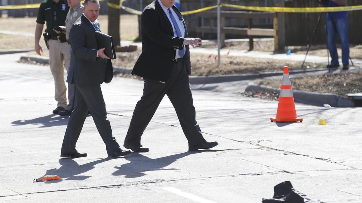 Investigators carefully examine the scene at Topeka and Kinkaid Tuesday afternoon after an officer was struck by a car driven by a felony suspect. The officers bulletproof vest lies int he street near a spike strip that was being deployed. (February 7, 2017)