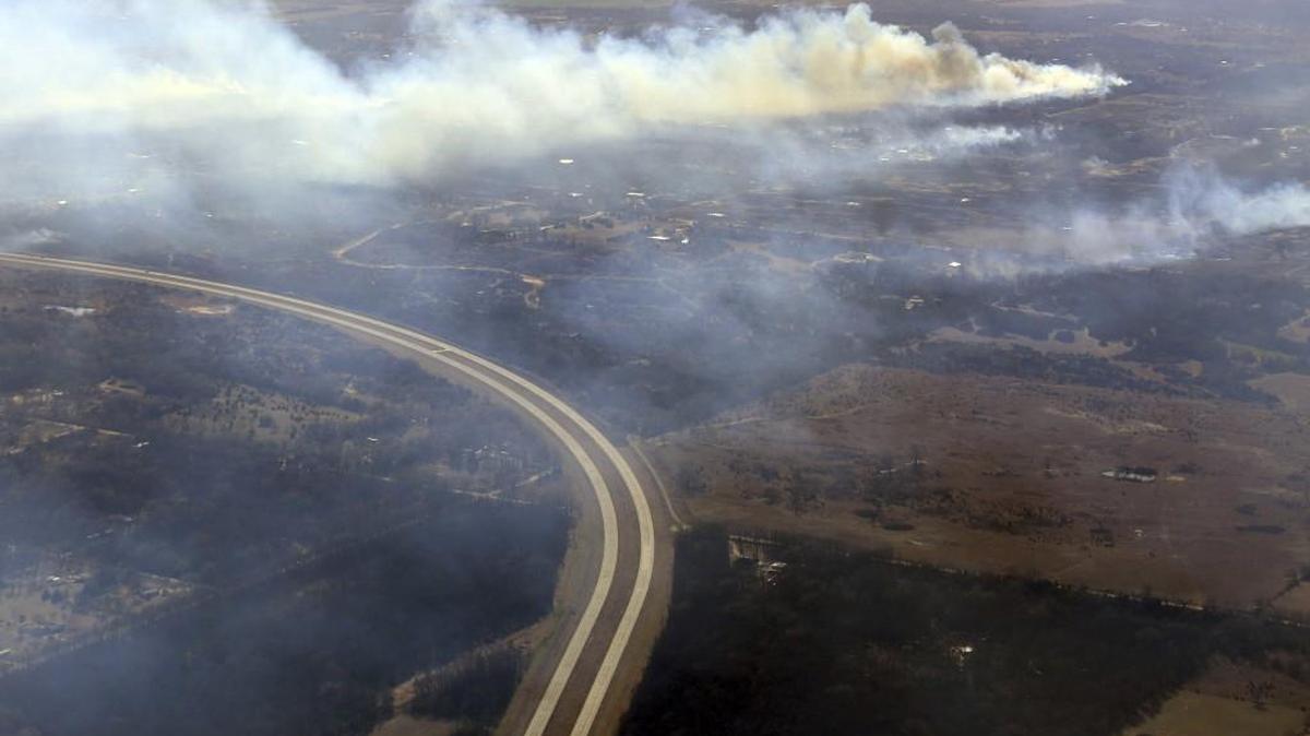 Wildfires burn north of Hutchinson on Tuesday. The view looks southwest along K-61 showing smoke billowing from a burning fire.