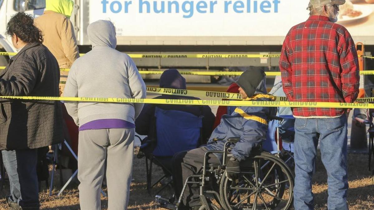 People stand in line before 8 a.m. Saturday outside the Bread of Life food pantry. The organization began its annual Thanksgiving food giveaway at 9 a.m. Hundreds of people lined up in the early morning cold to get a place in line.