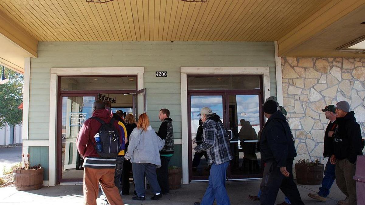 People stream into Bishop’s Family Dining on Saturday for a feast for the homeless provided by owner Luu Le.