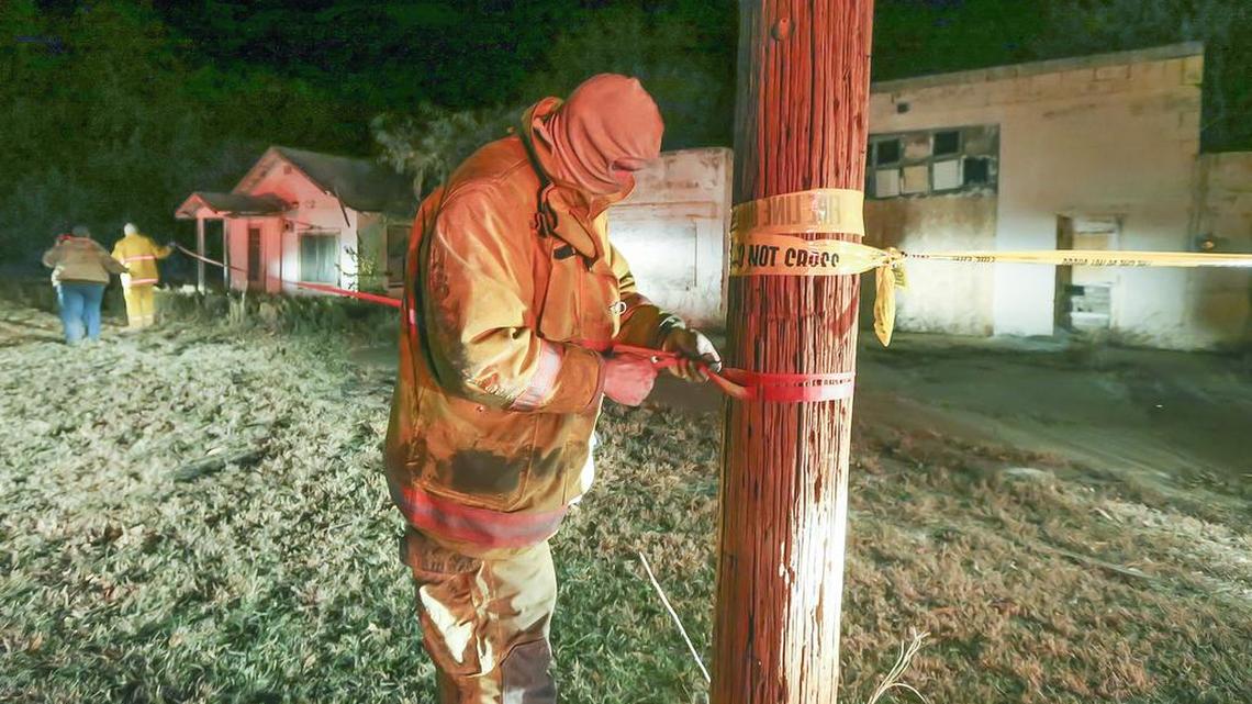
Argonia firefighter Justin Stringer puts crime scene tape around a building in Milan, Kan., that suffered structural damage after a 4.8 earthquake hit nearby last November.
