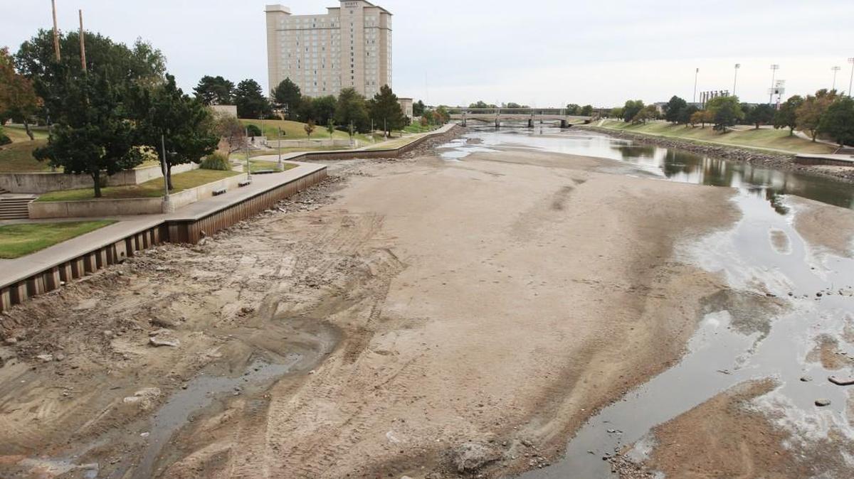 The Arkansas River, looking south from the Douglas Avenue Bridge in downtown Wichita, is extremely low, exposing the sandy riverbed, which is marked with trash, rocks and even some footprints. (Oct. 26, 2015)