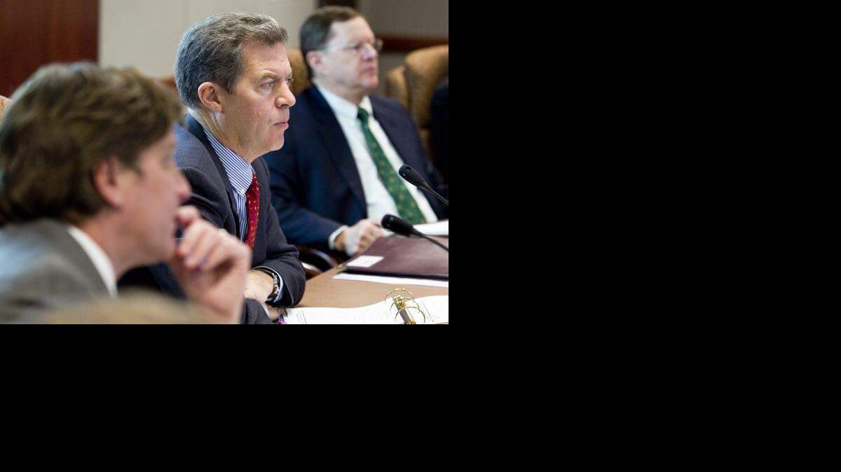 
Gov. Sam Brownback listens as Tyler Tenbrink, a senior labor economist with the Kansas Department of Labor, outlines the leading indicators of the Kansas economy during the Governor’s Council of Economic Advisors meeting Wednesday in Topeka. (Dec. 3, 2014) 
