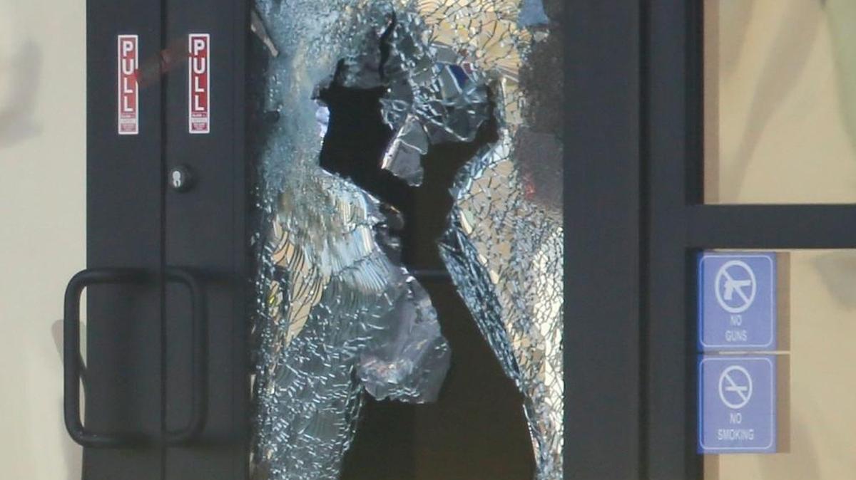 A shattered door marks the front entrance of Excel Industries in Hesston where Cedric Ford, an Excel employee, allegedly entered the factory, killed three people and wounded 14 others before being killed by police.