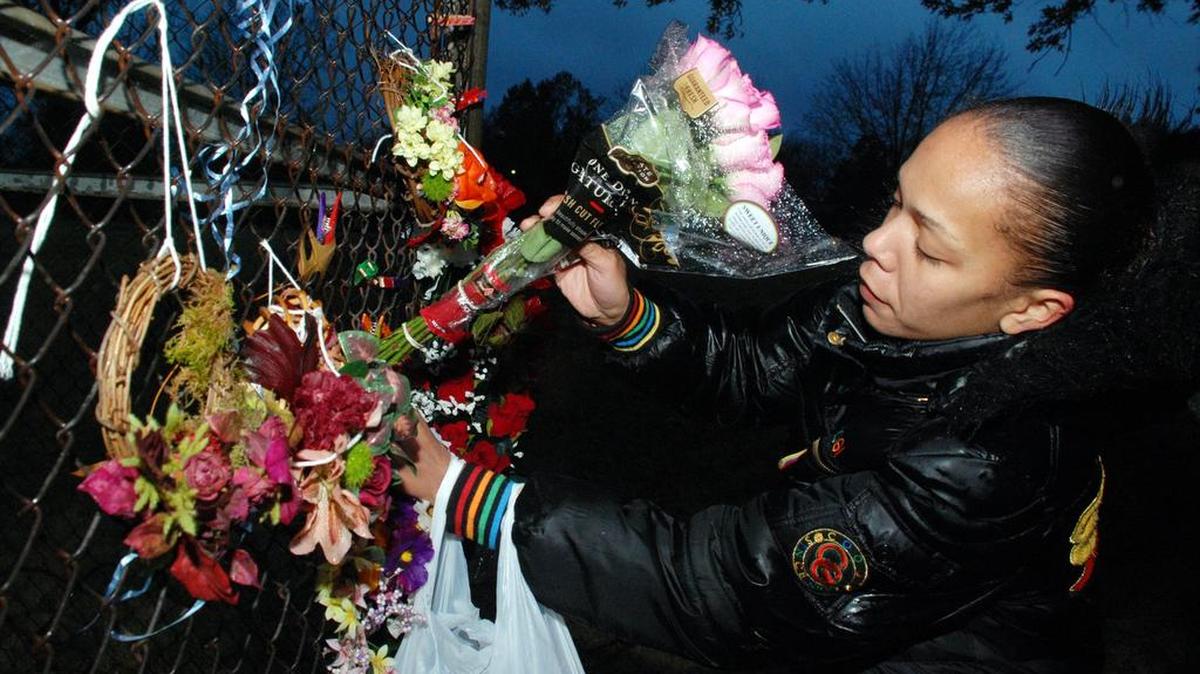 In this 2014 photo, Marcie Bell adds flowers to a memorial at a vigil for Letitia Davis at Fairmount Park. Two years after Davis was raped, set on fire and killed in the park, her accused attacker still hasn’t been arraigned on capital murder and other charges.