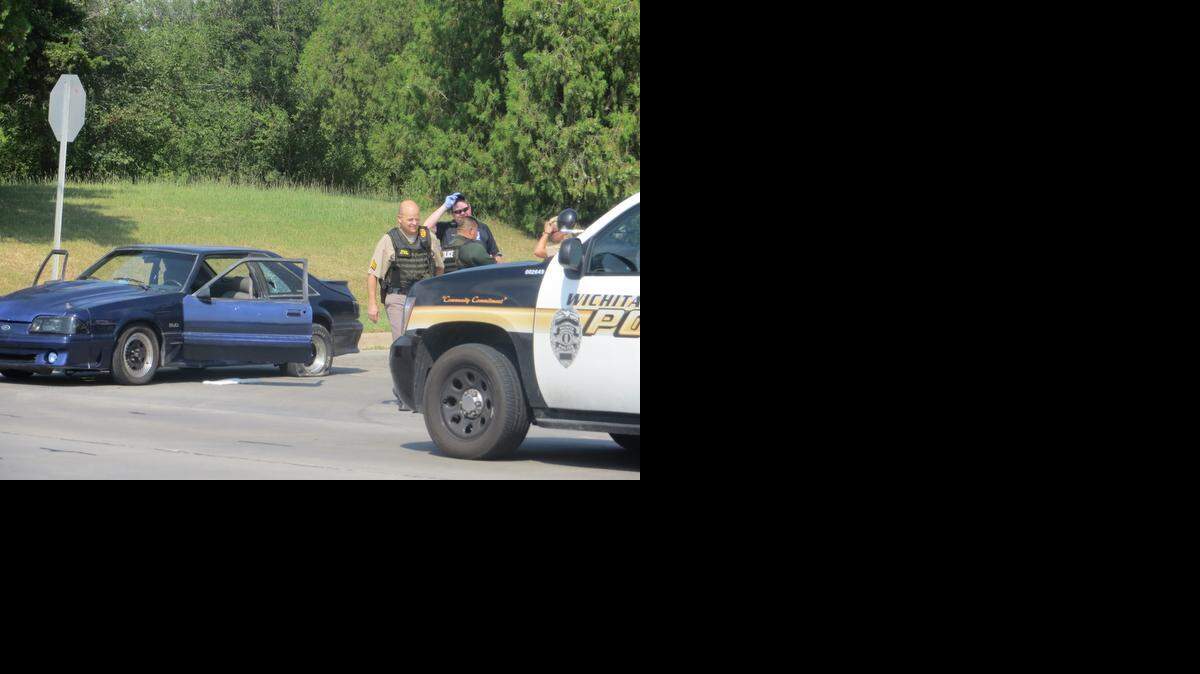 
Police investigate the shooting scene Monday afternoon at 12th and Hillside. The driver of the Mustang was shot by a man in a silver SUV. (Sept. 1, 2014)

