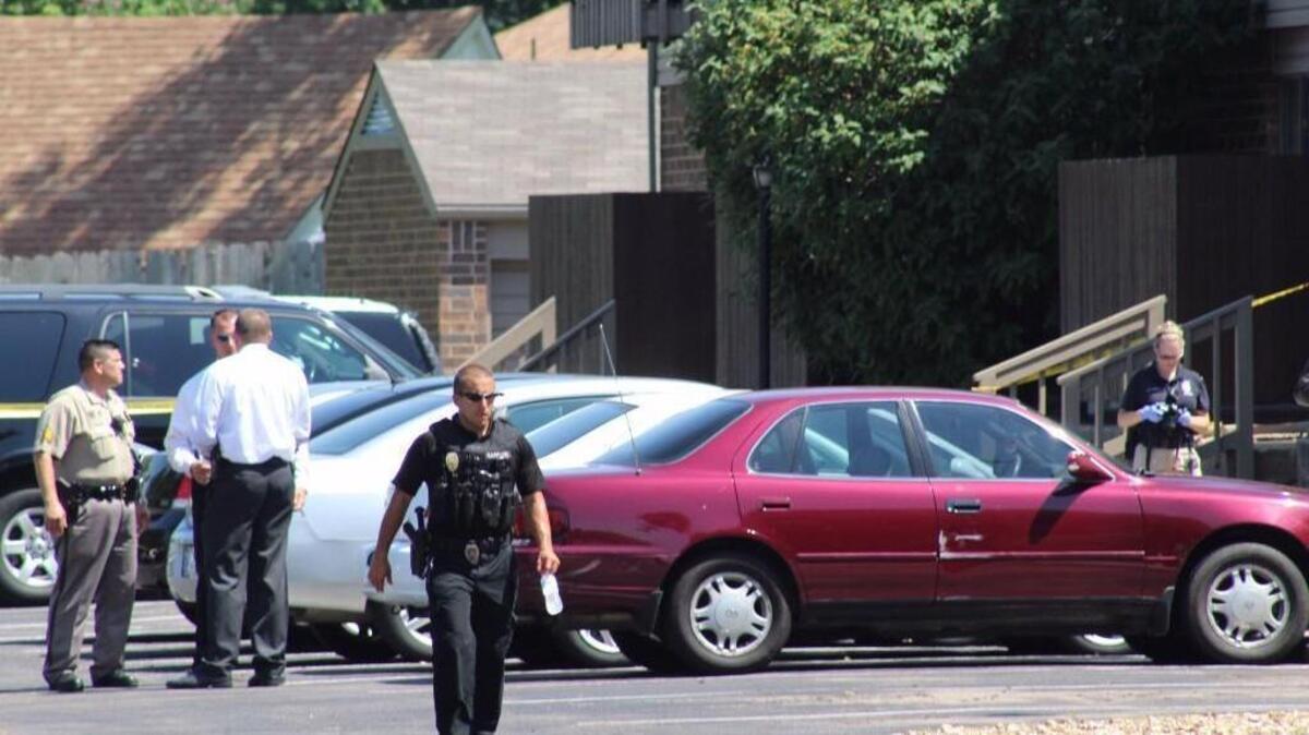 Police work the scene of a shooting on South Rock Road in which two people died.