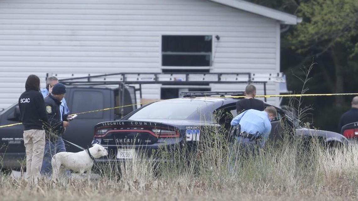 A man is patted down by a Sedgwick County sheriff’s deputy before being placed in the back of a cruiser at the scene of a shooting near Valley Center on April 1. Two people were shot at the home, near 93rd Street North and Oliver.