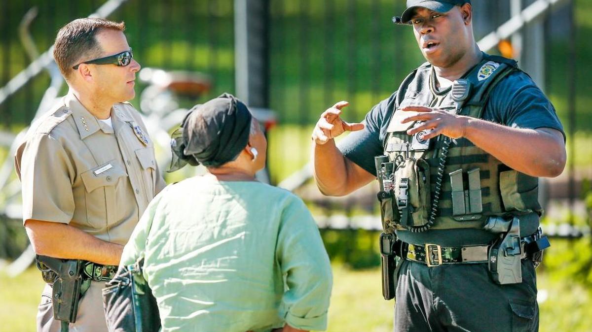 A resident talks with Wichita Police Chief Gordon Ramsay, left, and another police officer at the scene of a fatal shooting at the Calvary Towers at 25th and Grove. (May 4, 2016)