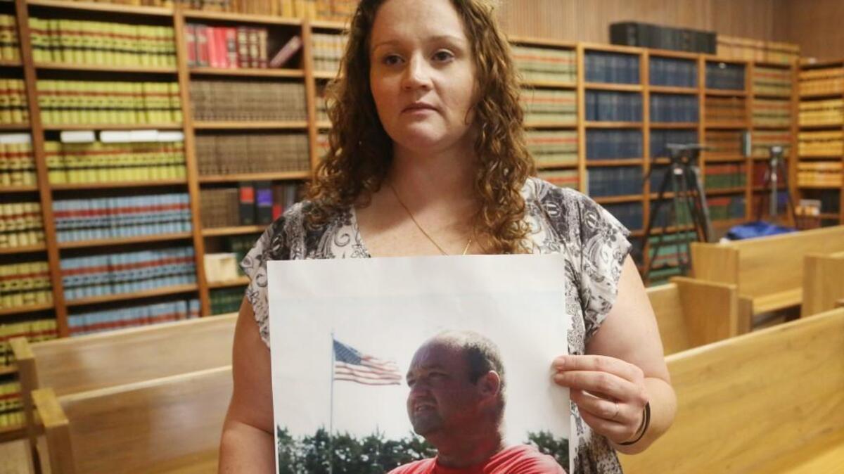 Kristina Myers holds a photo of her late husband Steven at the Barber County Courthouse. Myers won her first battle in a request to get sheriff's office body camera footage of her husband's  death in October.  Steven Myers was killed in Sun City by the Barber County undersheriff. (December 1, 2017)