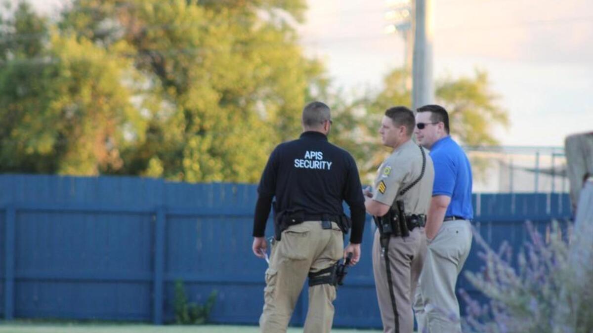 Wichita police Sgt. Jason Bartel talks with Newman University security officers on Friday about what emergency dispatchers described as a potential assault. A man in his 40s with injuries to the face was transported to Via Christi Hospital St. Francis in critical condition.