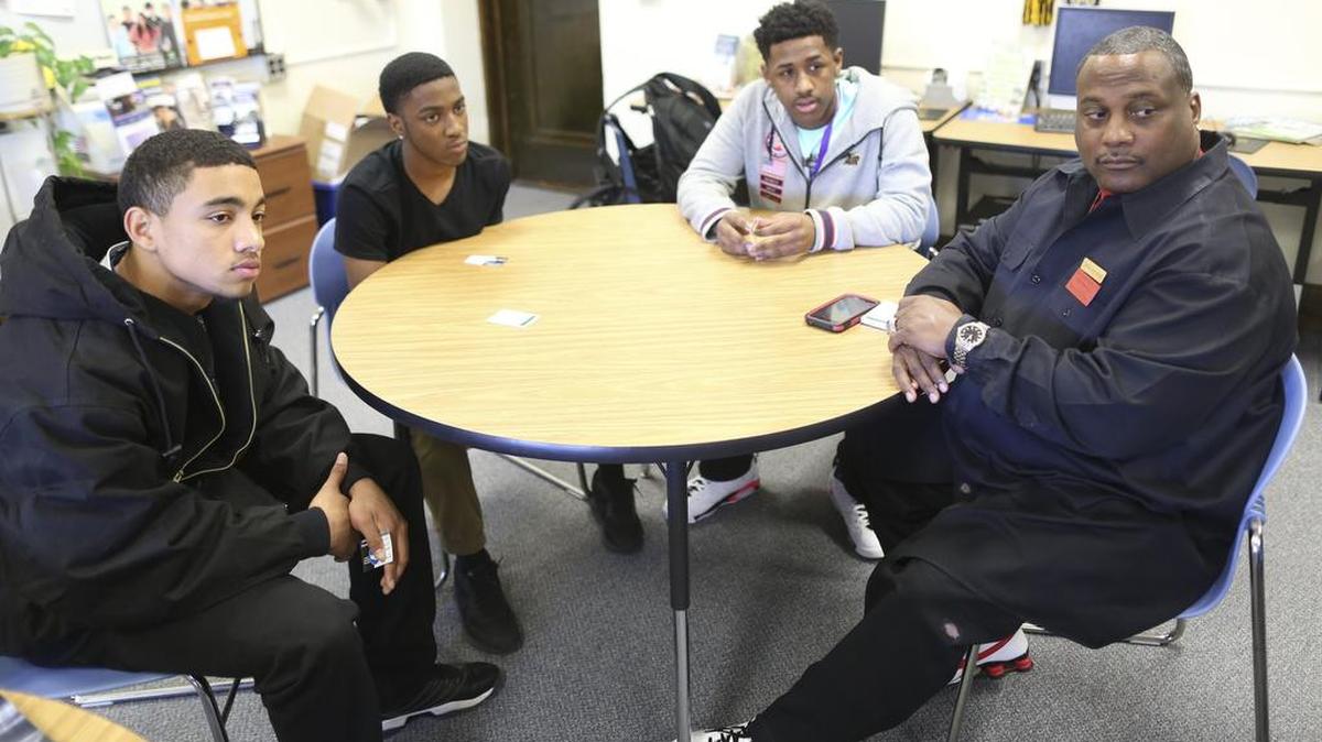 David Gilkey of Rise Up for Youth, right, and East High students Tony Patterson, left, Quintrell Royal and Kasi Ross have created cards that offer dos and don’ts when stopped by police.