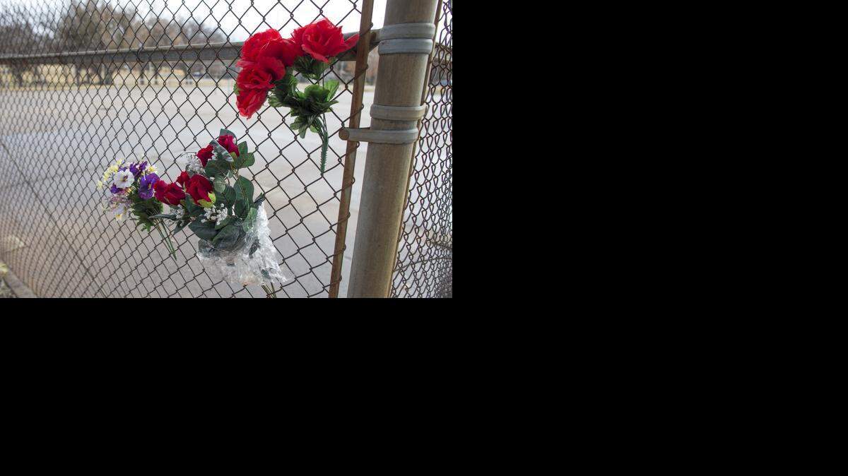 
Flower hang on a fence near the area in Fairmount Park where a woman was attacked, raped and burned Nov. 14. The woman died from her injuries on Saturday morning.
