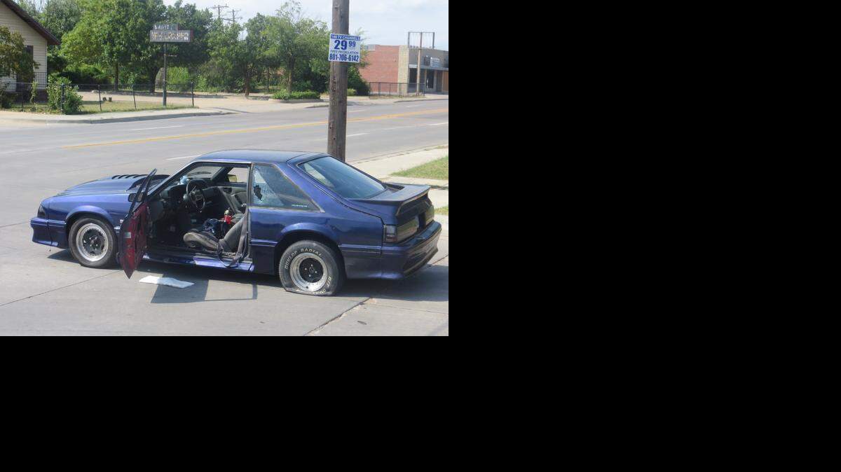 
A Ford Mustang sits at the scene Monday afternoon at 12th and Hillside after the driver was shot by a person in a silver SUV. (Sept. 1, 2014)

