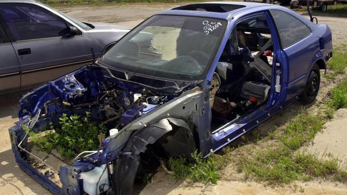 A 2000 Honda Civic sits completely stripped.