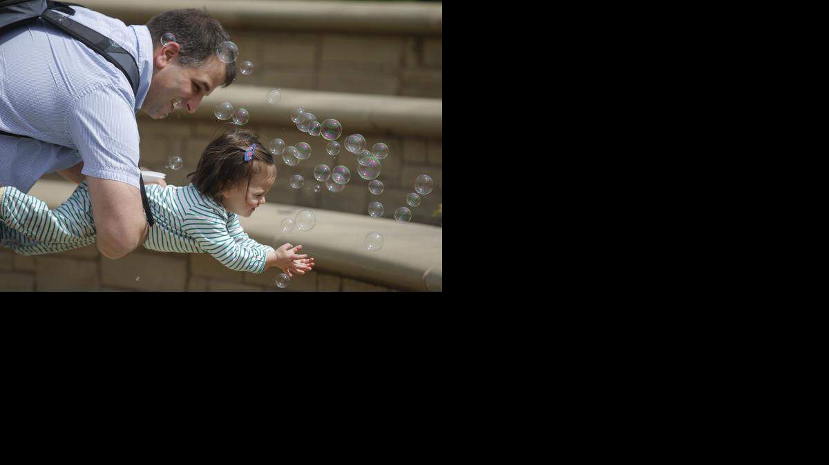 
Seth Ferreira holds his daughter, Vivienne, in front of a bubble machine during Botanica's Tulips, Fairies & Friends festival in April 2014.
