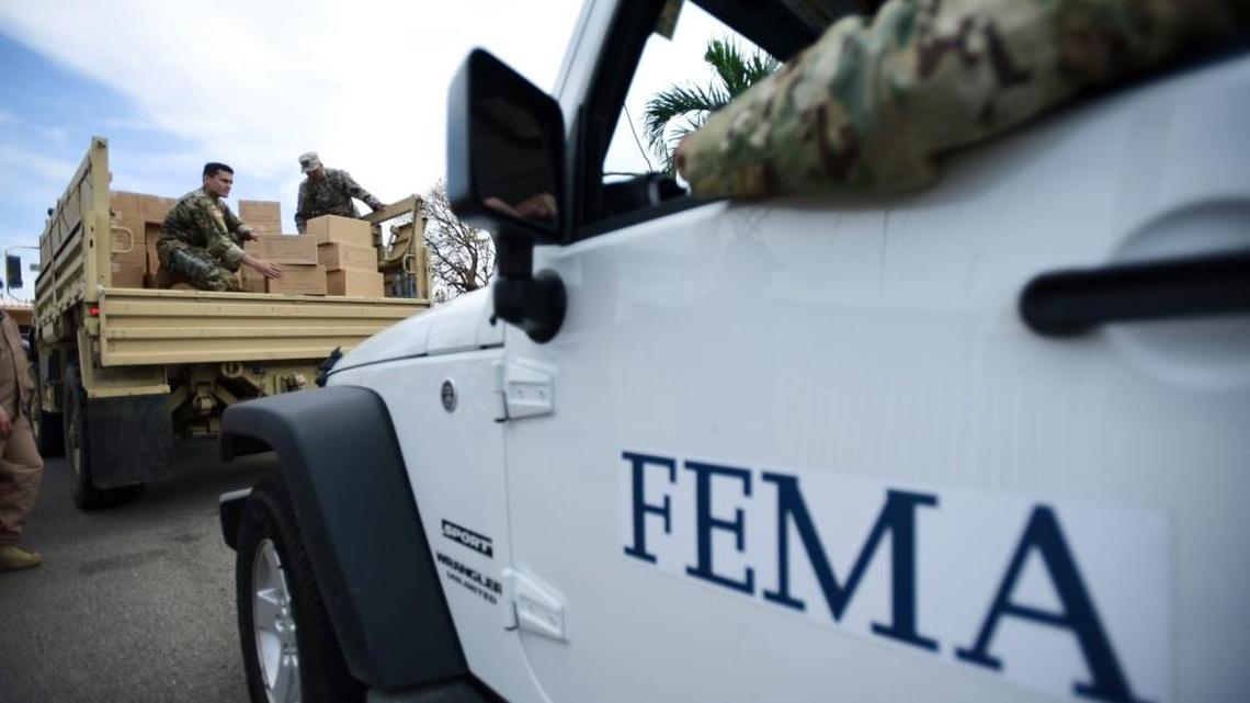 FILE - In this Oct. 5, 2017 file photo, Department of Homeland Security personnel deliver supplies to Santa Ana community residents in the aftermath of Hurricane Maria in Guayama, Puerto Rico.