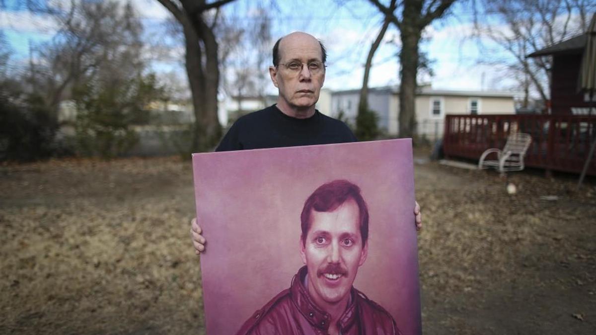 James Wilson holds a painting of his brother John at the home where John disappeared from in December 2015. Just before John went missing, he commissioned this painting of himself.