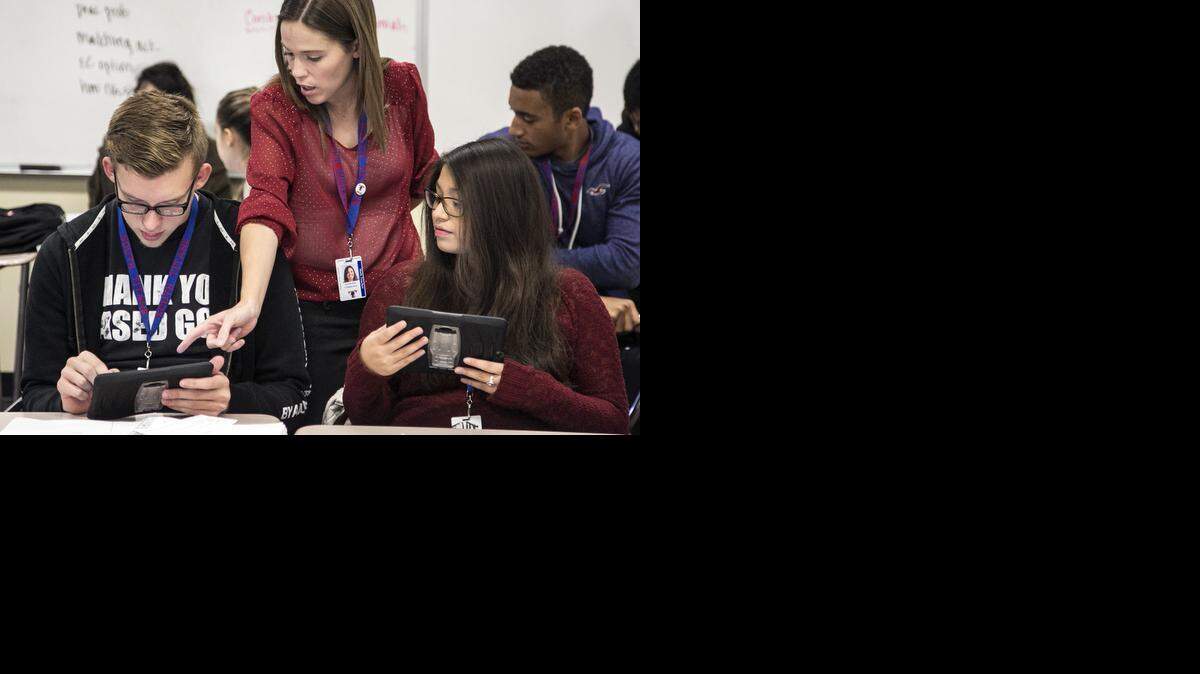 
South High math teacher Stephanie Chippeaux helps seniors Dakota Guthrie, left, and Citlaly Arevaio with a math problem on their iPads. As part of its “Five Schools in Five Days” event next week, the Wichita school district will showcase a new iPad initiative at South High. (Nov.14, 2014)

