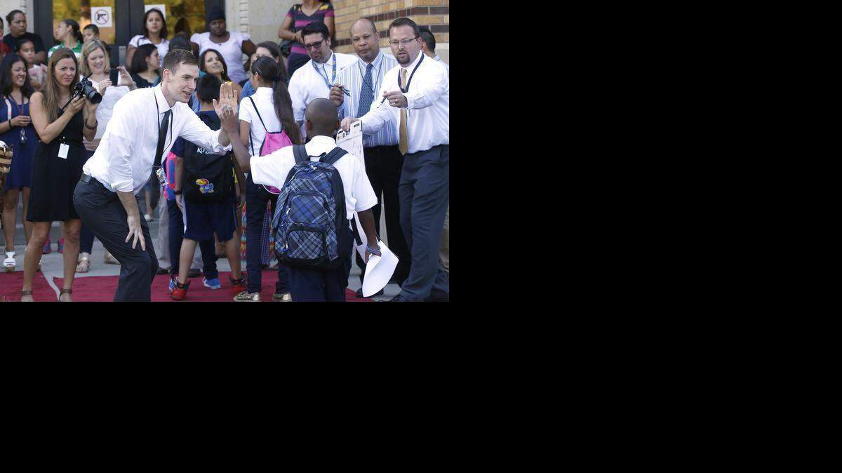 
Marshall Middle School teacher Ryan Kelley high-fives sixth-graders as they walked along the red carpet welcoming them to the school to begin the 2014-15 school year, which began on Aug. 12.
