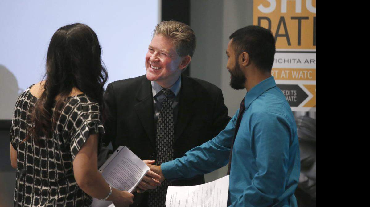 
Wichita Area Technical College president Tony Kinkel shakes hands with Shocker Pathway students Roxanna Gularte and Hasanul Khokon after a press conference announcing the launch of Shocker Pathway. The program is a partnership between WATC and Wichita State University that creates a joint associate of arts degree. Students will benefit because the program lowers the cost of getting a degree and removes the hassle of transferring from one school to another, said Tony Kinkel, WATC president. (April 20, 2015)

