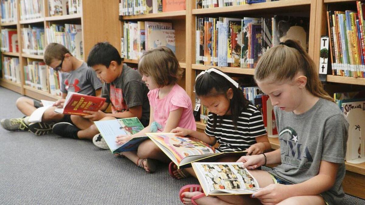 From left, Kilian Kelley, Thomas Nguyen, Ava Park, Hannah Huang and Ryelle Woods read in the library during summer latchkey at Christa McAuliffe Academy. (July 7, 2016)