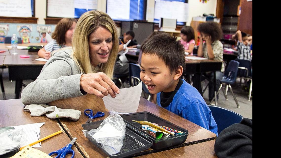 
Harry Street Elementary first-grade teacher Lori Pierce works with first-grader Sam Heng on an assignment. The Wichita school district has released details of a tentative teachers contract. (May 19, 2015)
