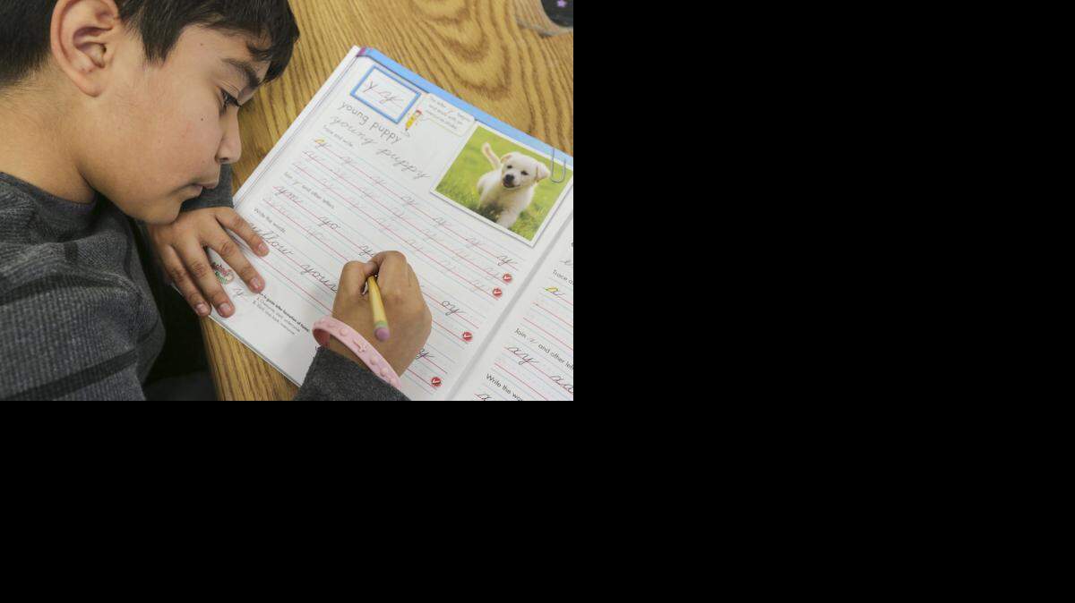 
Oscar Sanchez, a fifth-grader at Enders Elementary, works on his cursive handwriting on Thursday. The class is trying out an old-school handwriting curriculum to see how explicit cursive writing instruction might fit into today’s classrooms. 
