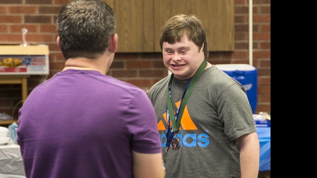 
Jason Crippen, special education teacher at East High, gives a letter to special-needs athlete Michael Kelley during a luncheon and ceremony Thursday. (May 7, 2015)
