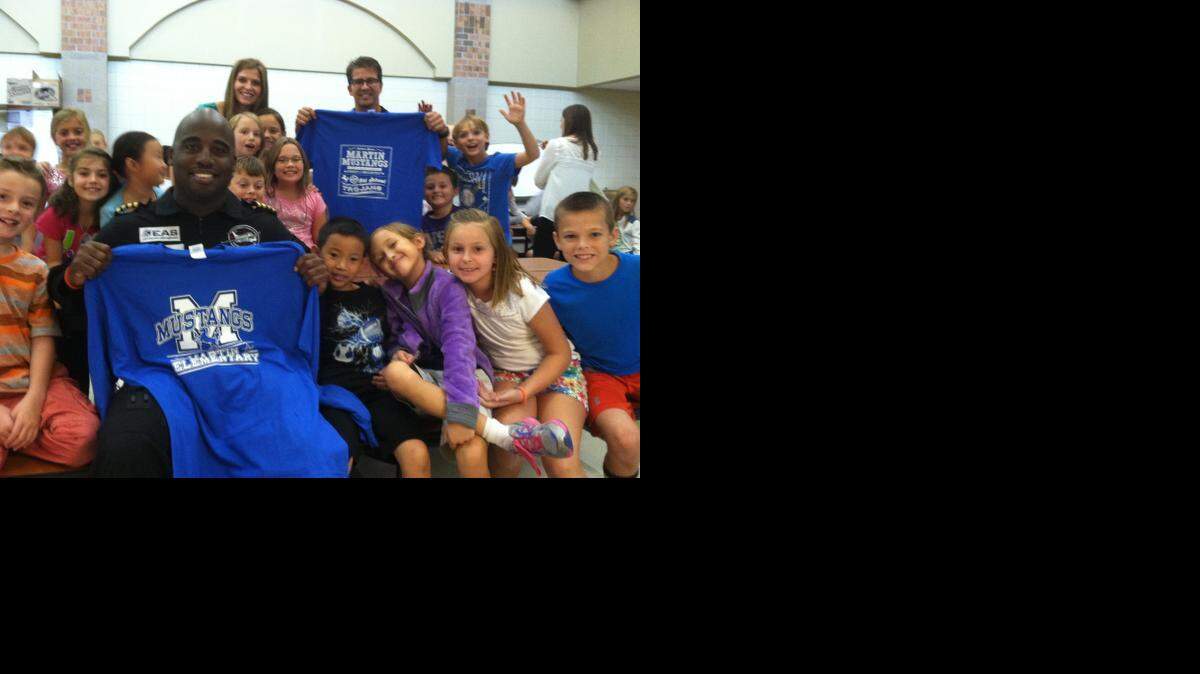
Pilot Barrington Irving, front, and Fabio Alexander Vasquez, part of the flight crew, pose with students at Martin Elementary in Andover. The men recently launched the first part of a three-year journey around the world, during which they will share discoveries with students and teachers back home.
