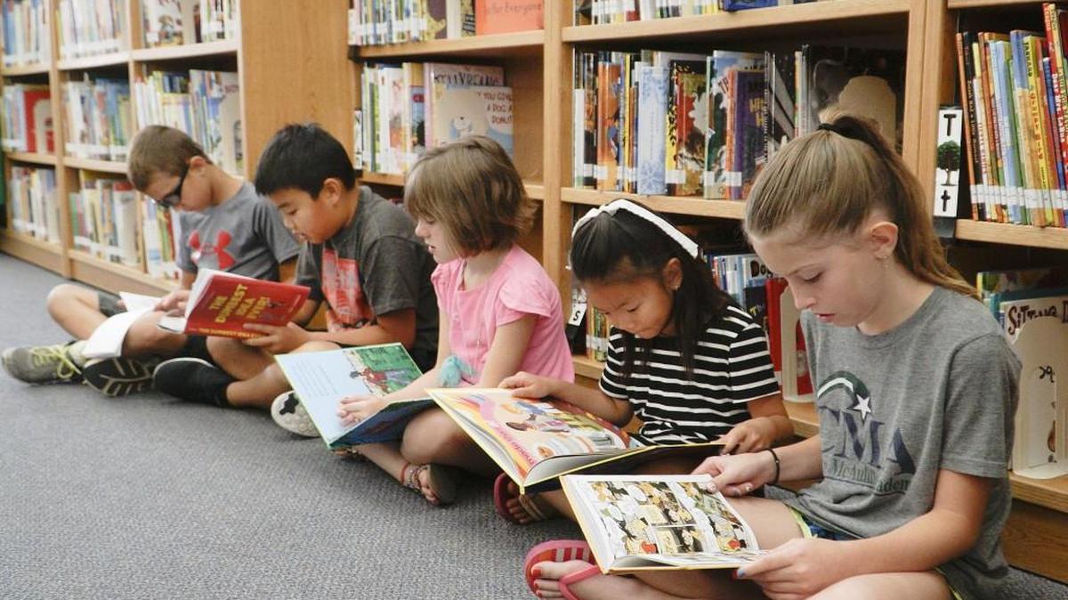 From left, Kilian Kelley, Thomas Nguyen, Ava Park, Hannah Huang and Ryelle Woods read in the library during the summer latchkey program at Christa McAuliffe Academy. (July 7, 2016)
