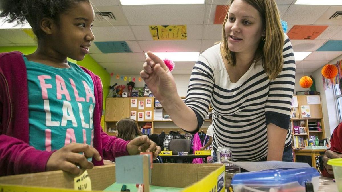 Allen Elementary fifth-grade teacher Nicole Johnson works with student Ariyana Ayers on a history project. (Jan. 29, 2015)