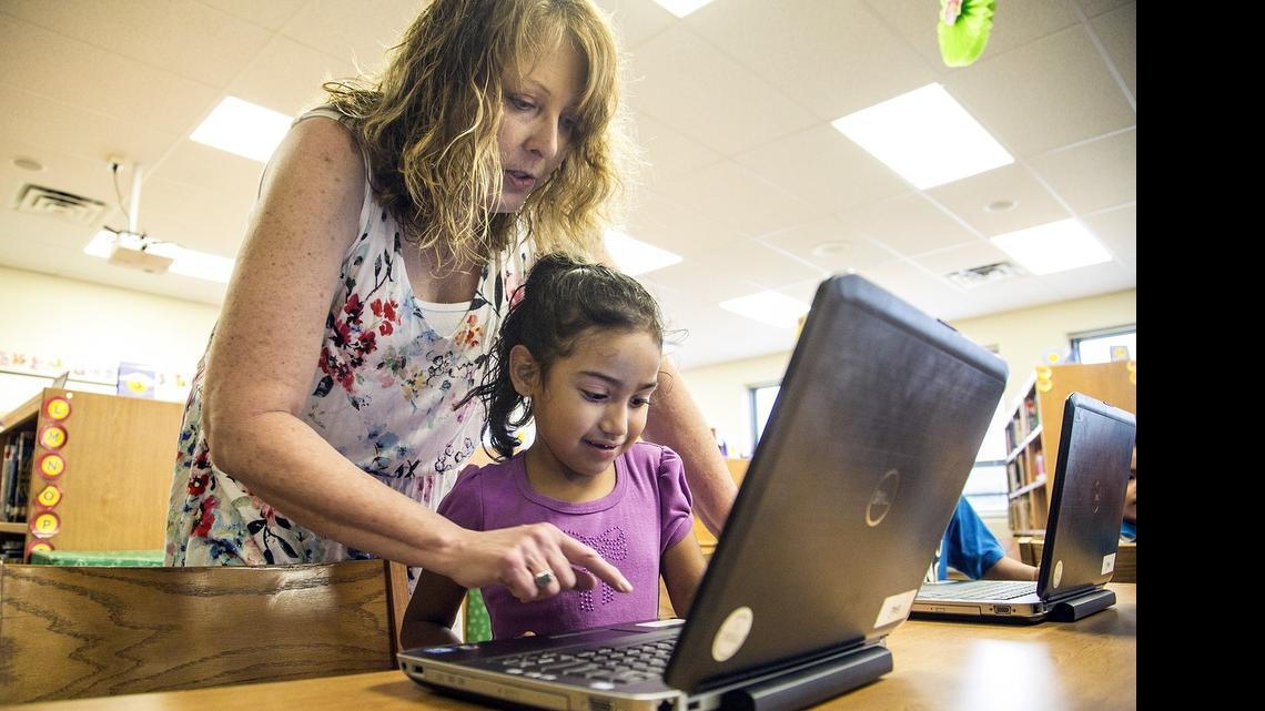 
Irving Elementary librarian Tracy Koppenhaver works with Jasmine Rochez during weekly summer library time. (June 17, 2015)
