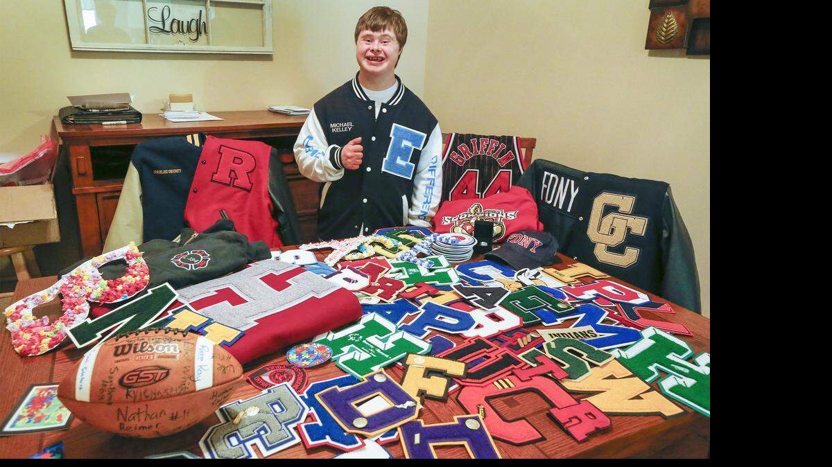 
Michael Kelley stands in the dining room of his house in Bel Aire on Friday with some of the varsity letters and memorabilia he has received from all over the country showing support for special-needs kids who participate in sports. 
