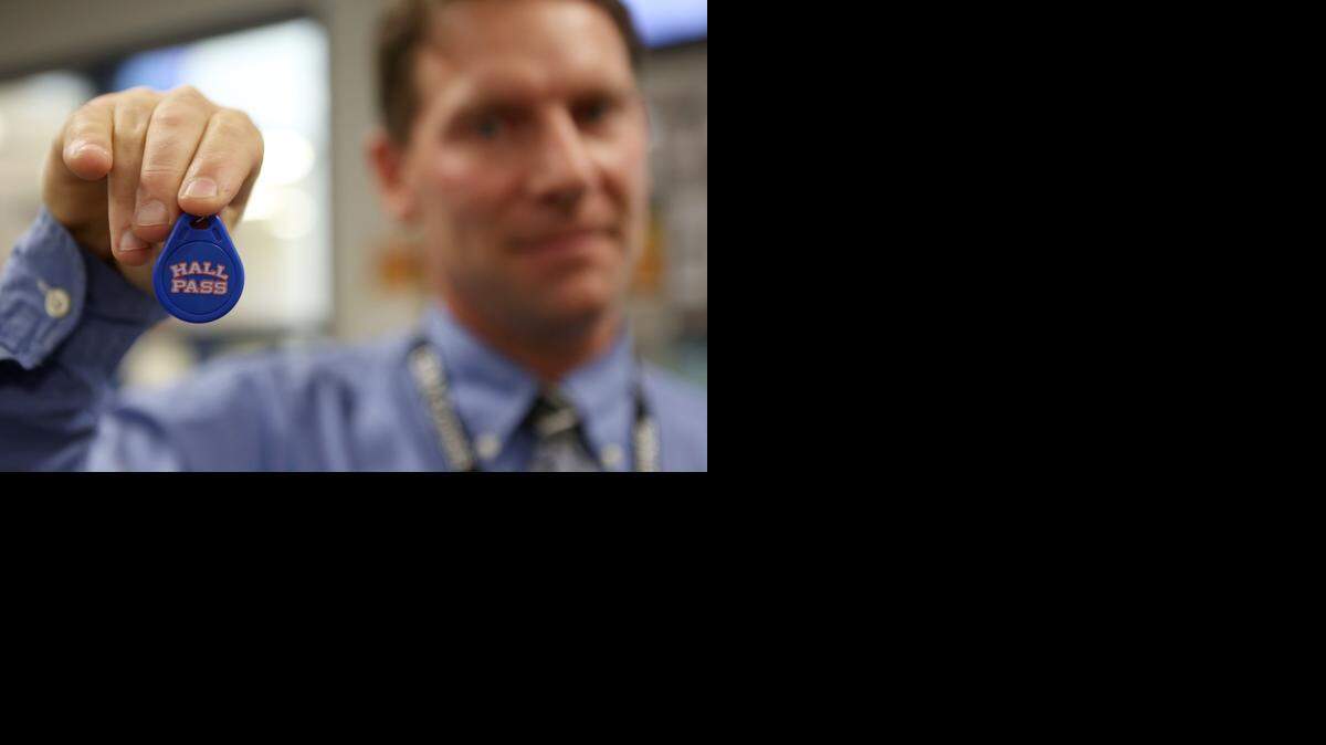 
Christa McAuliffe Academy Principal Shawn Springer demonstrates the new Hall Pass system that checks the identification of every visiting adult who goes into the school. It checks their name against a sex offender database. This key fob is given to adults who frequent the school. They wave it against a pad and then a visual check is done to make sure that is the correct person. (Aug. 21, 2014)
