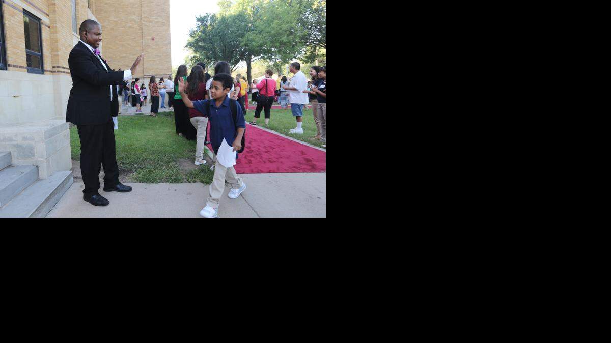 
Marshall Middle School Principal Ronald Stubbs high-fives sixth-grader Deshaun Ross as he walked off the red carpet. Teachers and school staff lined the red-carpeted entrance to the school as the sixth-graders entered for the first time. The seventh and eighth-graders will begin school on Tuesday. (Aug. 11, 2014)
