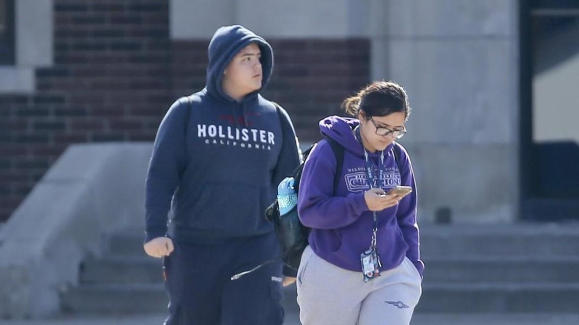 An East High School student uses her cell phone after stepping outside during a lunch break Tuesday. Each Wichita high school sets its own guidelines on cell phone use, usually allowing students to use phones before and after school, between classes and during lunch.
