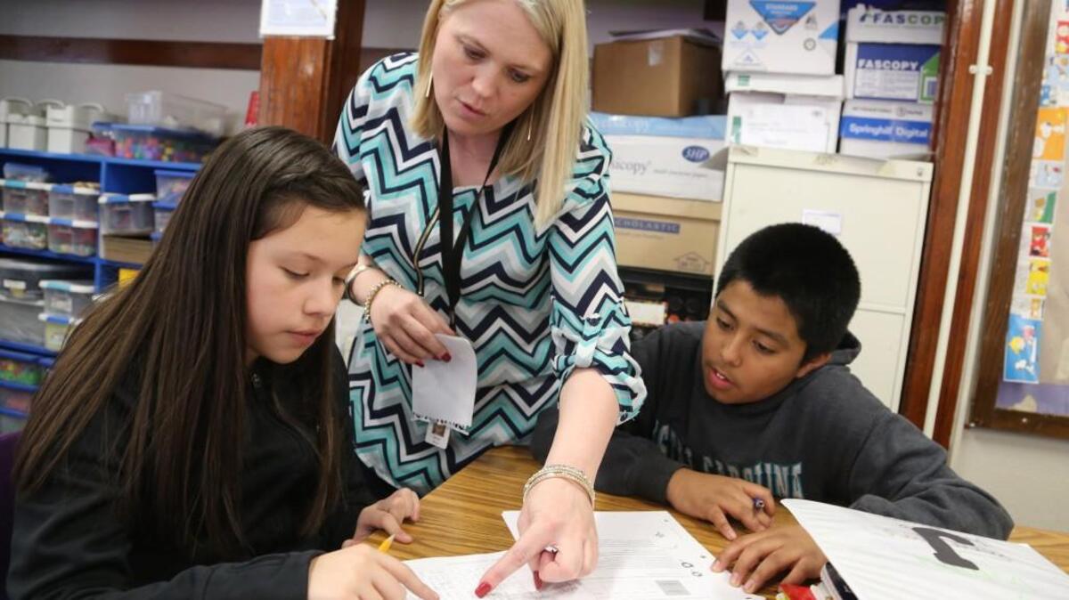 Hamilton Middle School teacher Melinda Mutuku works with Nayely Marquez, left, and Joseph Maldonado on Tuesday afternoon on a math project. The students have been using the new Carnegie Learning math curriculum that was adopted by the USD 259 School Board on Monday night. (March 14, 2017)