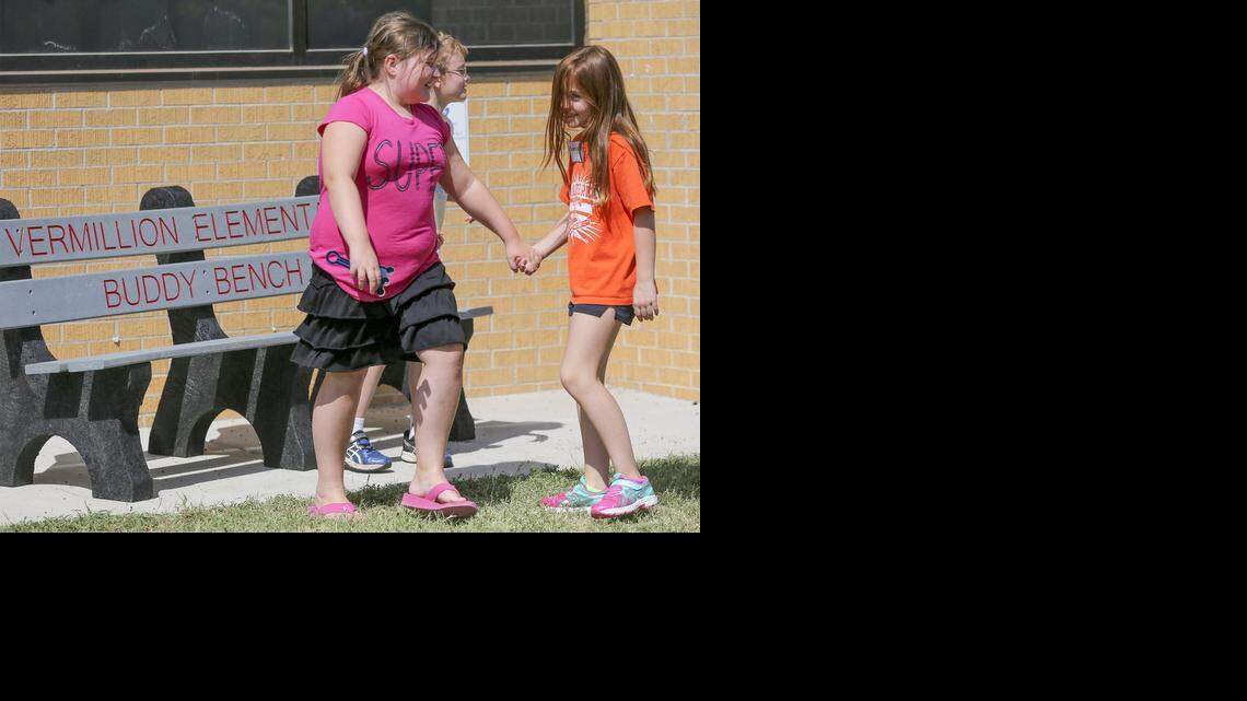 
Vermillion Elementary fourth-grader Samantha Roach, left, grabs the hand of her friend Addonna Powell who was sitting on the Buddy Bench during recess Friday. The idea of the bench is to foster new friendships and combat loneliness. (Aug. 29, 2014)
