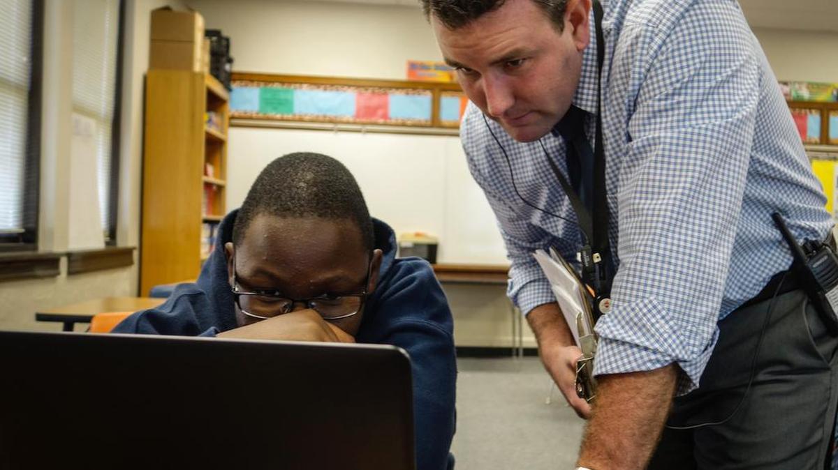 Justin Kasel, the principal at Hamilton Middle School, watches Christopher Kasalika work independently on a computer during math class while his teacher helps a small group. Kasel changed the schedule so all students could take an extra math and English class. (Nov. 14, 2016)