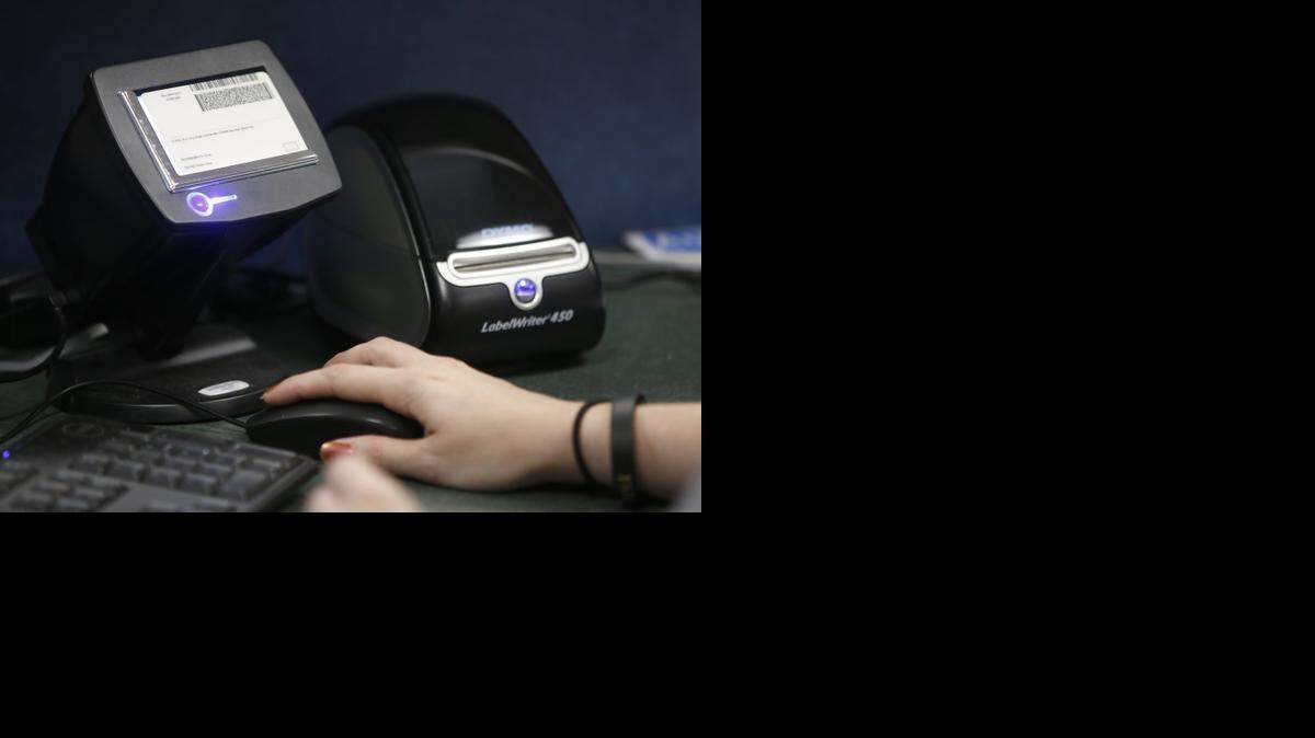 
A driver’s license is scanned into the Hall Pass system at Christa McAuliffe Academy. It checks the identification of every visiting adult who goes into the school against a sex offender database. (Aug. 21, 2014)
