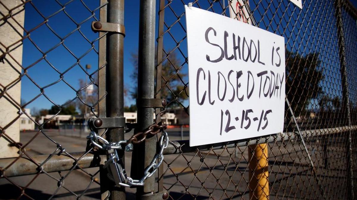 A gate to Birmingham Community Charter High School is locked with a sign stating that school is closed, Tuesday, Dec. 15, 2015, in Van Nuys, Calif. All schools in the vast Los Angeles Unified School District were ordered closed due to an electronic threat Tuesday.