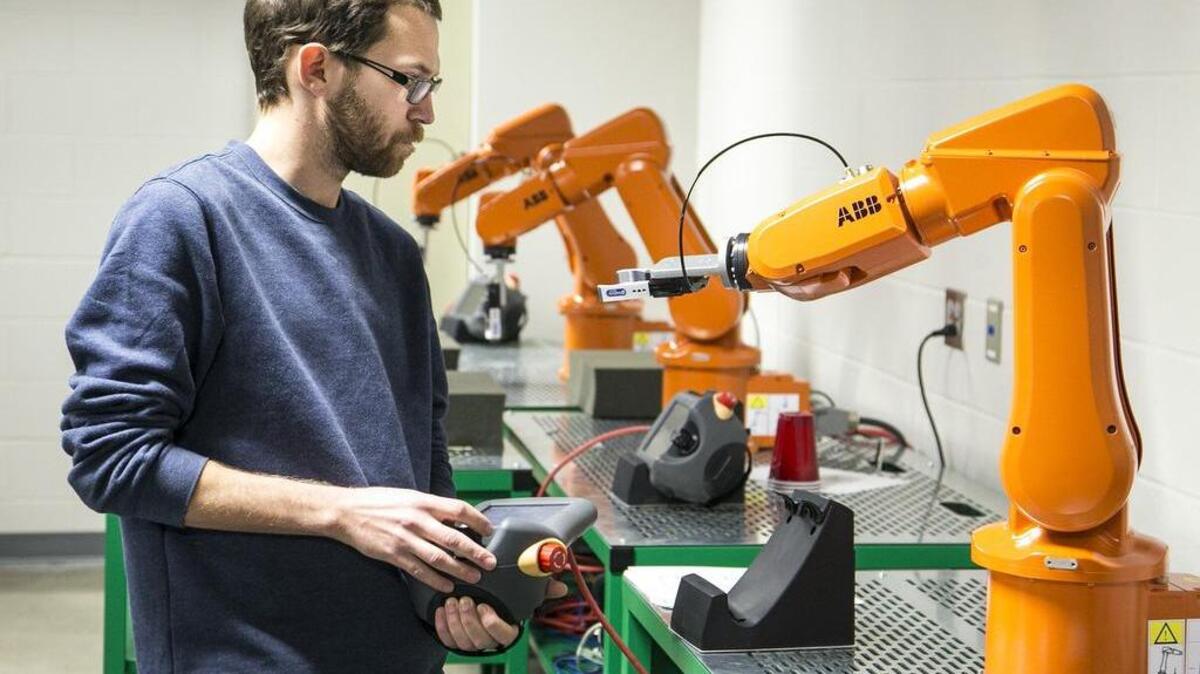 Wichita State electrical engineering student Brent Duncan programs a robotic arm at the Wichita Area Technical College. (Feb. 13, 2015)