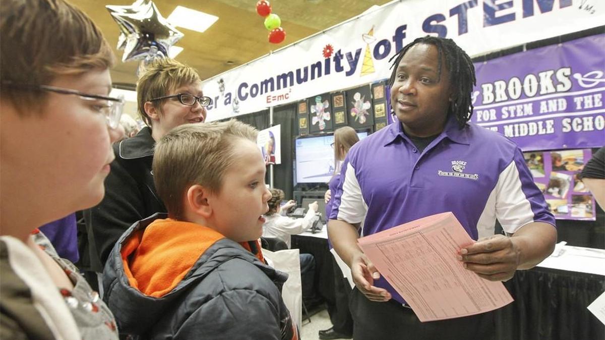 A representative for Brooks Middle School Center for STEM and the Arts, right, talks with students at Choices Fair in 2014.