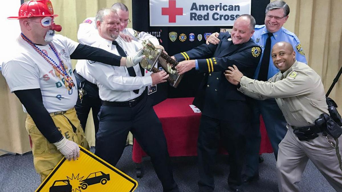 Sedgwick County EMS Capt. Greg Gering (white shirt) on Wednesday playfully keeps the trophy away from the other branches of first responders that competed in the Battle of the Badges blood drive. Not only do the winners get a trophy, they also get bragging rights over the other first responders. (Jan. 4, 2017)