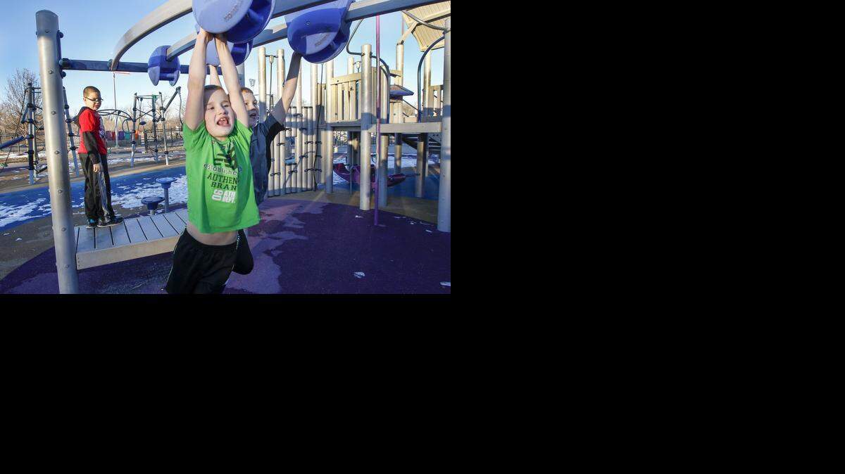 
Eight-year-old Jade Stafford, left, and his brother, Jared Campbell, 12, play on the jungle gym at Sunrise Boundless Playscape in Sedgwick County Park. (Jan. 15, 2015) 
